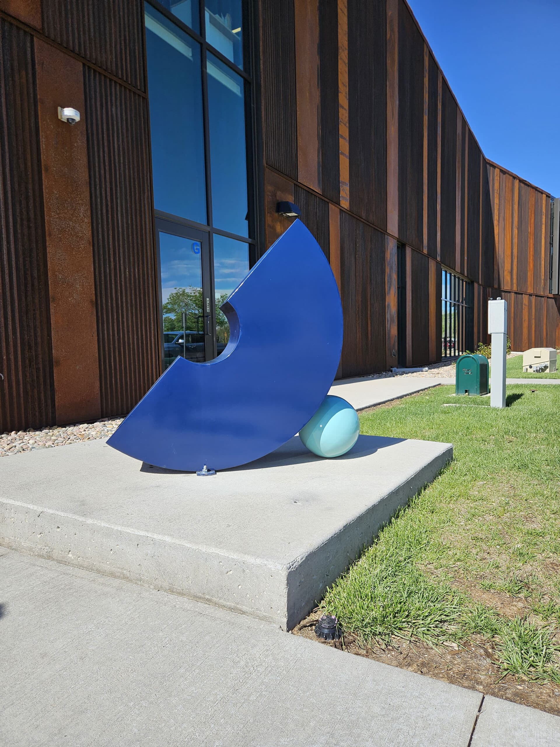 Bond is a visual representation of the profound bond between a mother and her child. The sculpture looks somewhat like a blue letter "c" turned on it's side with a small lighter blue circle on the side.