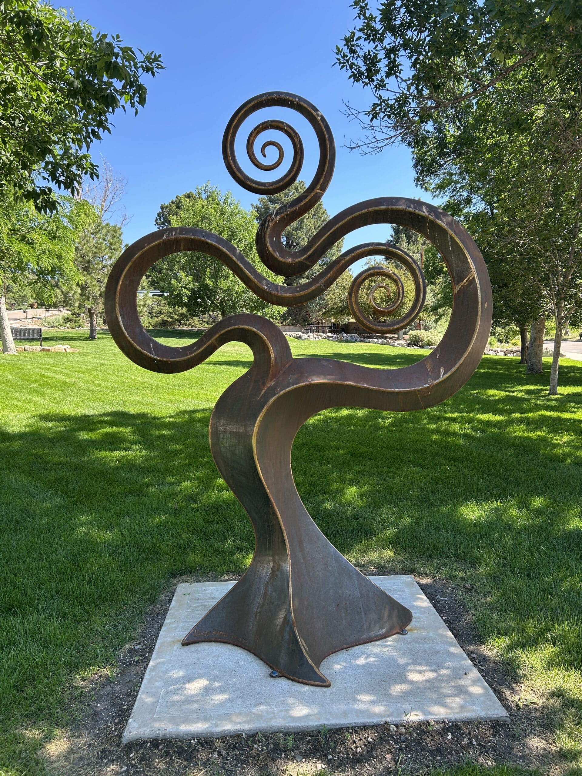 Heart of the Valley is a large abstract steel sculpture that takes on elements from the plant and animal kingdom such as overlapping branches that dip in the middle which almost appear to form the hills and valleys of a landscape.