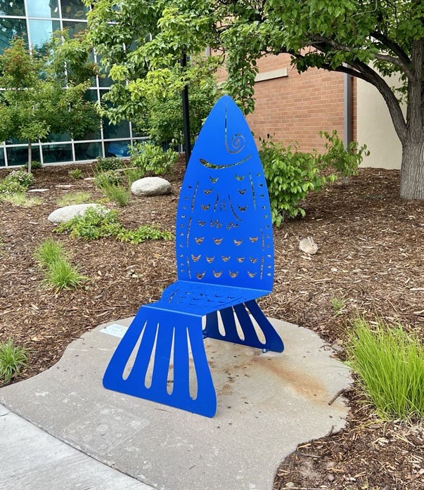 Poisson is an outdoor sculpture in the shape of a chair that looks like a blue fish. Have a seat!