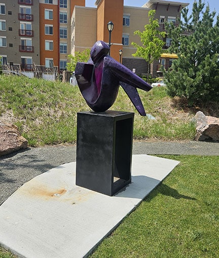 What a Kick is a sculpture with someone curled up with their knees against their chest and kicking out.